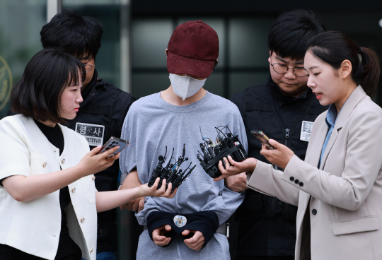 데이트폭력 신고에 불만을 품고 연인을 살해한 혐의로 구속된 김모씨가 1일 오전 서울 금천경찰서에서 검찰로 송치되고 있다.   연합뉴스